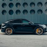 a black porsche cayen is parked in front of a building