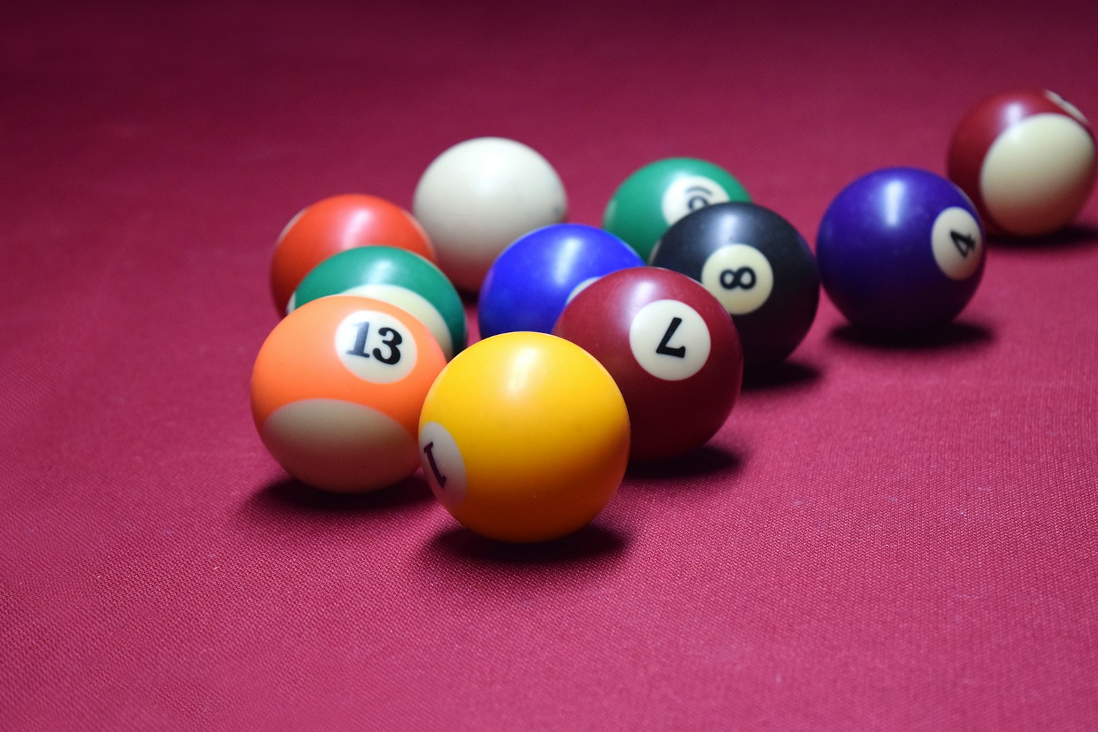 billiard balls lined up in a row on a pink surface