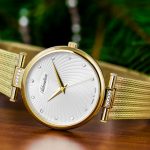 shallow focus photography of round gold-colored analog watch